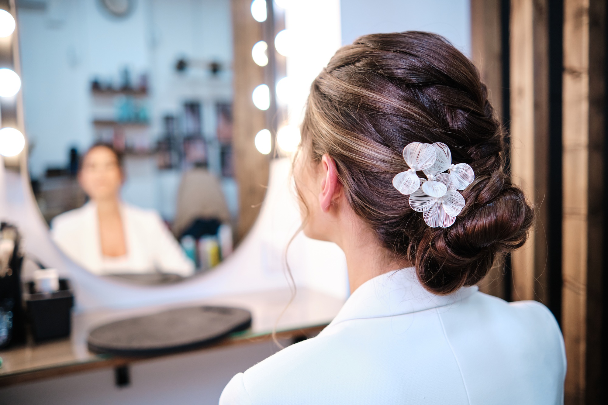 View of a woman having a hairstyle with stylish hair accessories at the hair salon.